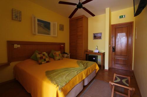 a bedroom with a bed and a ceiling fan at Kira's Boutique Hotel in Mindelo