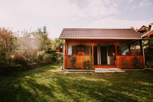 a small house with an orange fence in a yard at Bosnyák Panzió in Odorheiu Secuiesc
