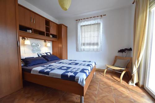 a bedroom with a bed and a chair in it at Apartments Villa Dolmar in Vodice