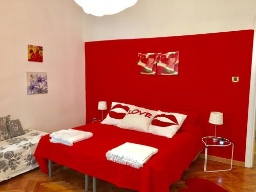 ein rotes Schlafzimmer mit einem Bett mit rotem Kopfteil in der Unterkunft Casa del Cucciolo in Triest