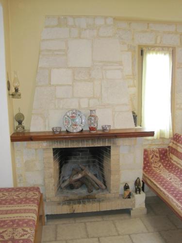 a living room with a stone fireplace with a plate on it at Vamos Palace Apartments in Vamos