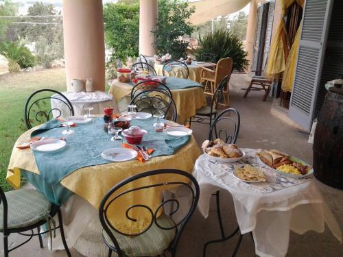 un gruppo di tavole con piatti di cibo sopra di Guest house Villa di Judighes a Cerveteri