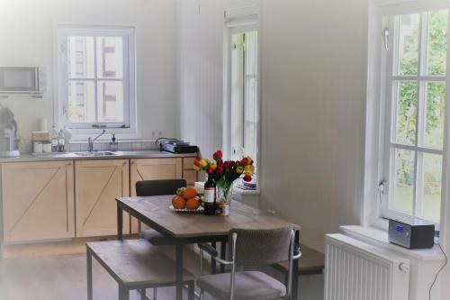 eine Küche mit einem Tisch mit Blumen und Obst darauf in der Unterkunft Gina's garden house in Amsterdam
