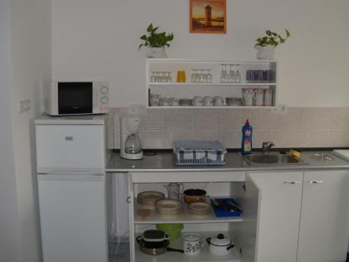 a kitchen with a sink and a white refrigerator at Pataki House in Mórahalom