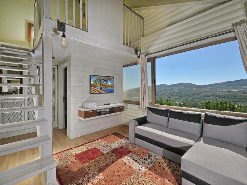 a living room with a couch and a large window at White Suites in Majdal Shams