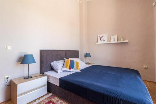 a bedroom with a bed with a blue bedspread at Villa Ingrid in Poreč