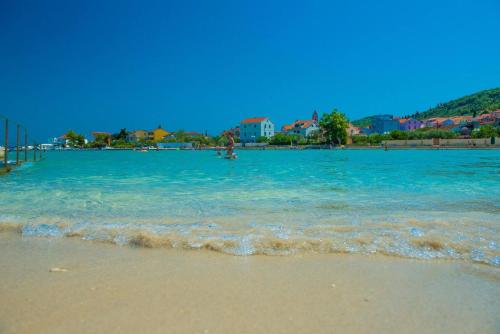 a beach with blue water and buildings in the background at Vile Dalmacija in Preko