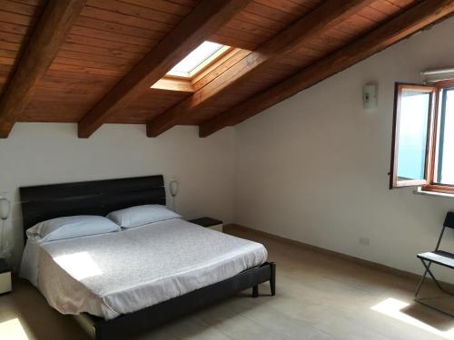 une chambre avec un lit dans une pièce avec des plafonds en bois dans l'établissement Casa Vacanze Casa Barbara, à Finale Ligure