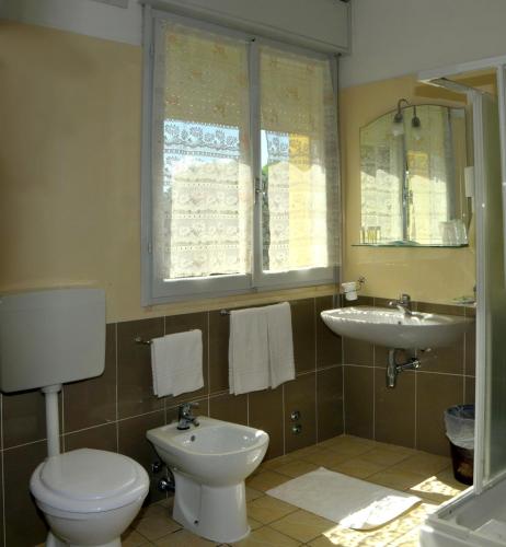 a bathroom with a toilet and a sink at Hotel Levante in Cervia
