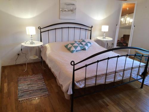 a bedroom with a bed with two lamps and a mirror at Apartman Lucy in Slatine