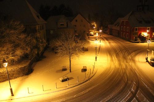 a snow covered street at night with street lights at Gasthaus Zur Sonne in Freiburg im Breisgau