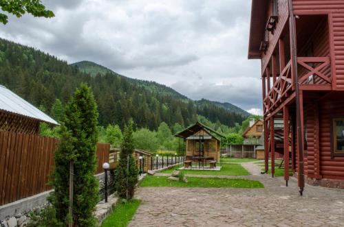 a courtyard of a house with mountains in the background at Svitlana in Tatariv
