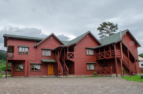 a large red wooden house with a staircase at Svitlana in Tatariv