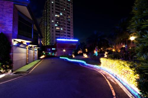 a city street at night with buildings and lights at Beverly Commercial Motel in Luzhu