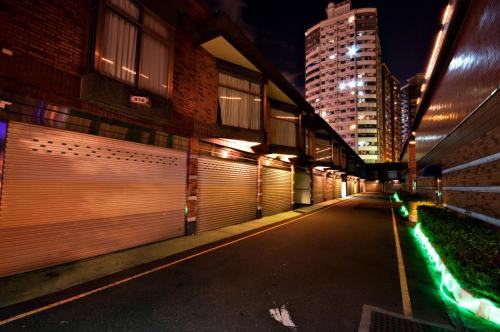 an empty street at night with buildings and lights at Beverly Commercial Motel in Luzhu