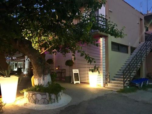 a house with a tree in front of a building at Teatro Deluxe Rooms in Kato Rodini