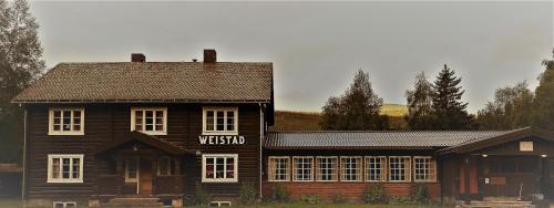 a wooden house with a sign on the side of it at Weistad in Heidal