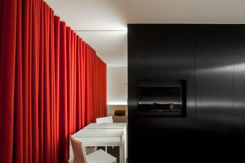a room with a red curtain and a white table and chair at Hotel 3K Europa in Lisbon
