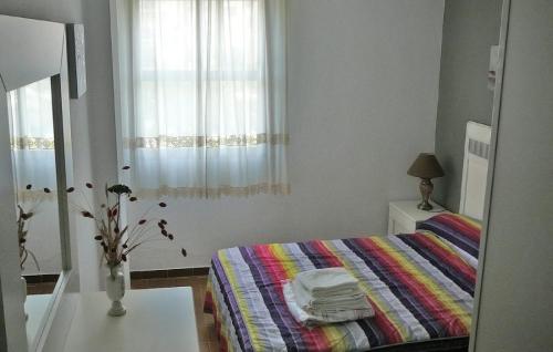 バルバテにあるApartamento El Faro Barbateのベッドルーム1室(カラフルな毛布、窓付)