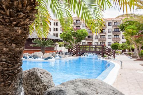 a swimming pool with a bridge in a hotel at Balcon del Mar en la Costa in Costa Del Silencio