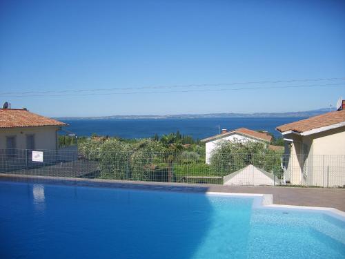a large blue swimming pool in front of a house at Hotel Panoramica in Bardolino