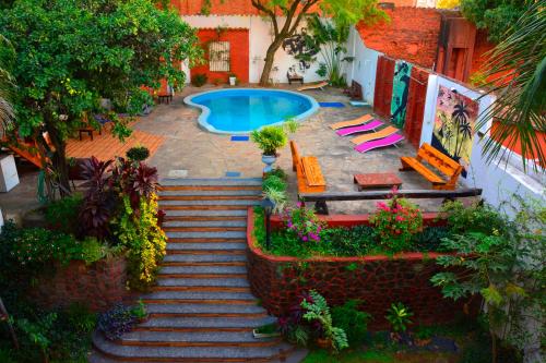 a staircase leading to a swimming pool with lounge chairs at El Viajero Asuncion Hostel & Suites in Asuncion
