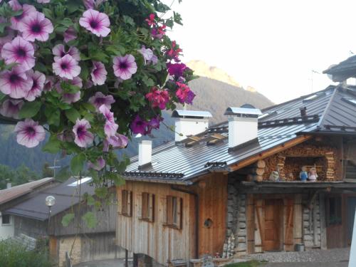 Una casa con flores rosas colgando de ella. en Chalet Ory, en Vigo di Fassa