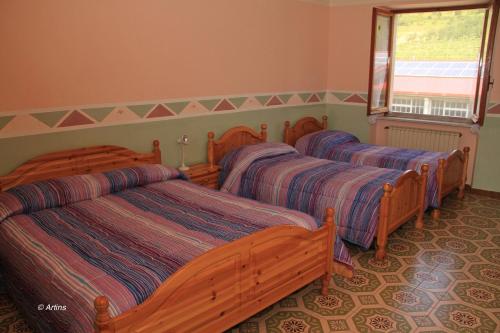 a bedroom with three beds and a window at Agriturismo La Praduscella in Fivizzano