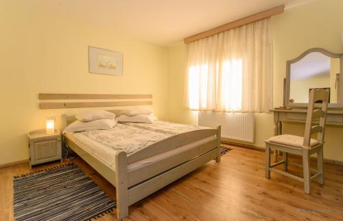 1 dormitorio con cama, silla y espejo en Pensiunea La Despani, en Brasov