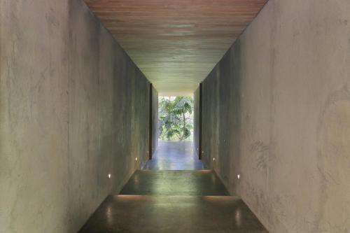 a hallway of a house with a concrete wall at Chameleon Villa Bali in Tabanan