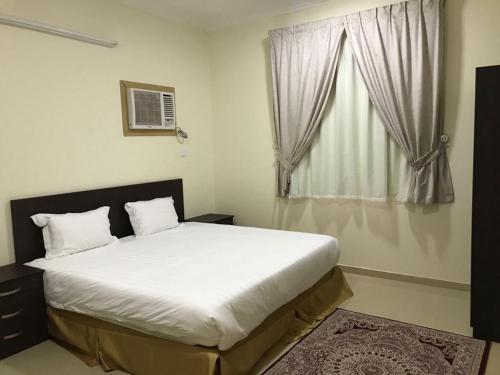 - une chambre avec un grand lit et une fenêtre dans l'établissement رفيف الشمال - الحائط Rafeef Al Shamal, à Al Ḩāyiţ