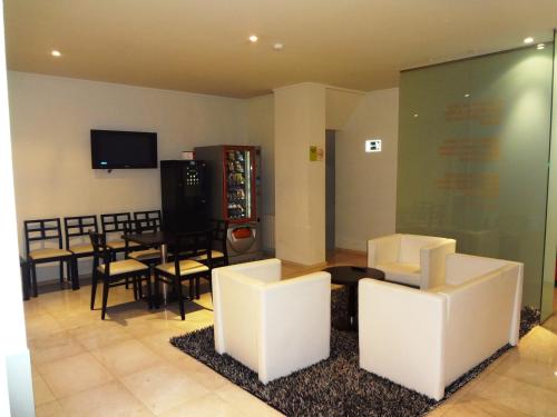 salon z białymi krzesłami i jadalnią w obiekcie Hotel Irixo w mieście Ourense