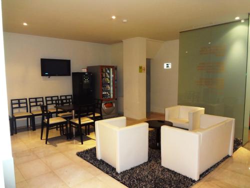 sala de estar con sillas blancas y comedor en Hotel Irixo, en Ourense