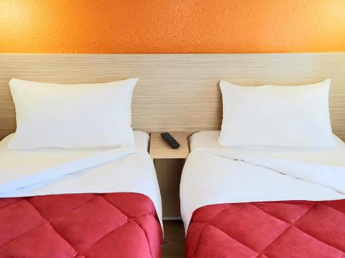 two beds sitting next to each other in a room at Premiere Classe Lille Sud - Seclin in Seclin