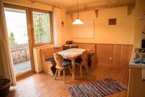 une cuisine avec une table et des chaises ainsi qu'une fenêtre dans l'établissement Appartment Krassnig, à Turracher Höhe