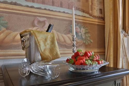 a table with a candle and a bowl of strawberries at Relais Villa Poschi in Pugnano