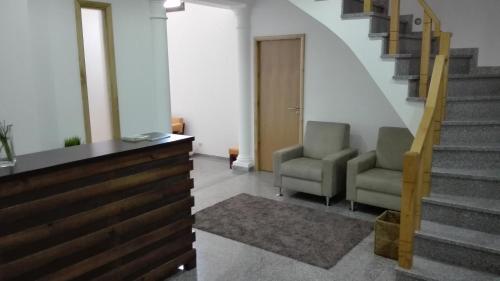 a hallway with two chairs and a stair case at VistaFreita- Rooms & Suites in Arouca