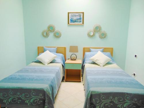 two beds in a room with blue walls at Villa Antonio Calderisi in Vieste