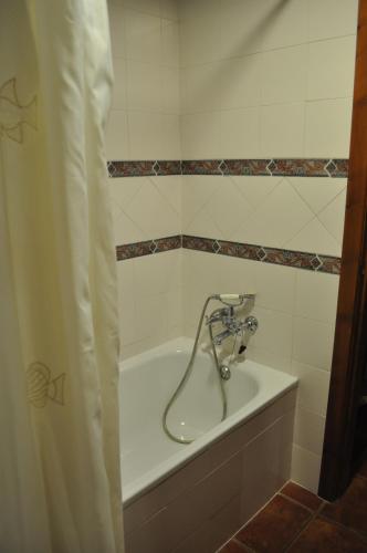 a bathroom with a bath tub with a shower curtain at Apartamentos Rurales Peralta in Segura de la Sierra