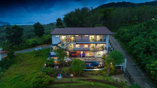 Chalong -Villa Nap Dau Crown - 8 Br Private Pool Villa - Phuket في تشالونج: اطلالة جوية على منزل به انوار