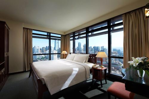 a hotel room with a large bed and large windows at Berjaya Times Square Hotel, Kuala Lumpur in Kuala Lumpur