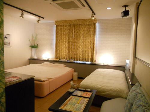 a hotel room with two beds and a table at Hotel Mare (Adult Only) in Akashi