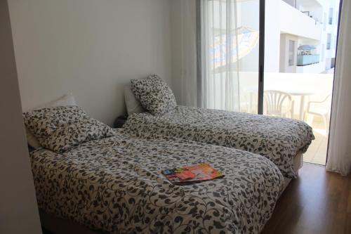 a bedroom with a bed and a chair and a window at Paradise Beach in Mansouria