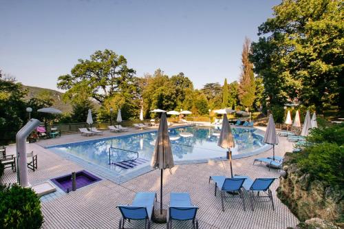 una grande piscina con sedie e ombrelloni di Park Hotel Villa Potenziani a Rieti