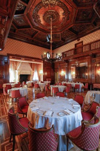 a dining room with a table and chairs and a fireplace at Park Hotel Villa Potenziani in Rieti