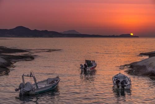 two boats sitting in the water at sunset at Fani Dream Suite in Pachaina