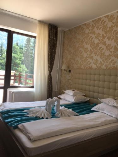 a bedroom with a bed with towels on it at Pensiunea Orizont in Poiana Brasov
