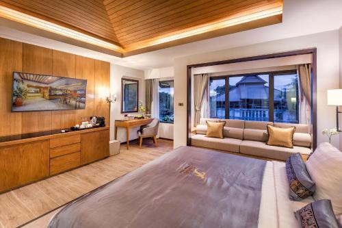 Un dormitorio con una cama grande y un sofá. en Jomkitti Boutique Hotel, en Chiang Mai