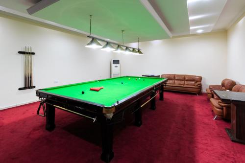 a living room with a pool table in a room at Palma Beach Resort & Spa in Umm Al Quwain