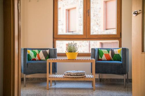 two chairs with colorful pillows and a table in a room at Albergue de Prioro in Prioro